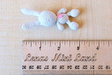 Miniature bunny knitted dollhouse toy. Little Amigurumi crochet animal rabbit with heart.